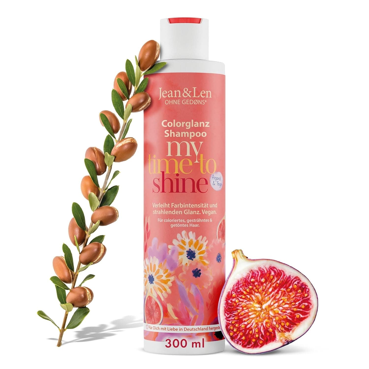 Lachsfarbene Shampooflasche mit weißem Deckel von Jean & Len, Aufschrift Ohne Gedøns mit Sternchen, Colorglanz Shampoo, my time to shine, Arganöl und Feige, verleiht Farbintensität und strahlenden Glanz, vegan, für coloriertes, gesträhntes und getöntes Haar und 300 ml, daneben ein Arganzweig und eine halbierte Feige
