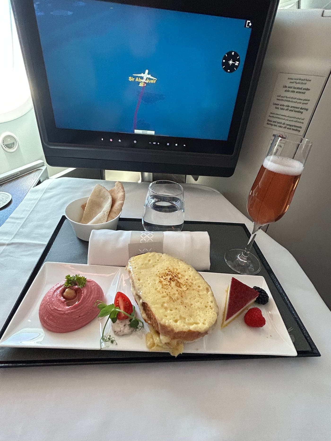 Mittagessen an Bord, auf dem Bildschirm die Route über die Insel Sir Abu Nuair im Persischen Golf